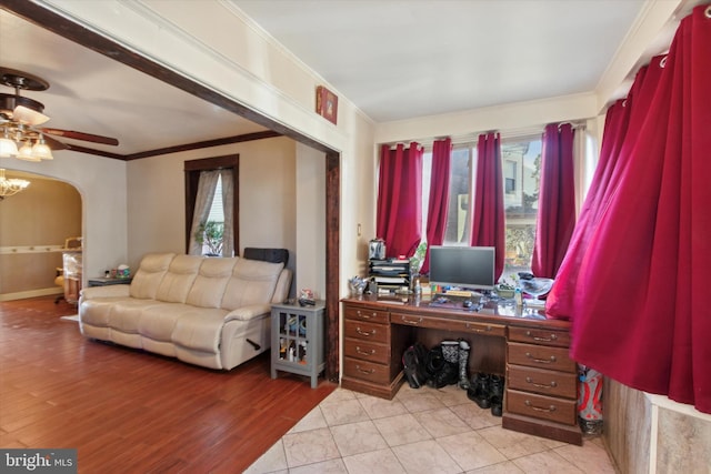 home office with ceiling fan, ornamental molding, and light wood-type flooring