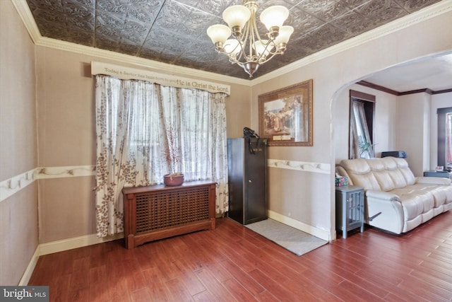 entryway featuring a chandelier, hardwood / wood-style flooring, and ornamental molding