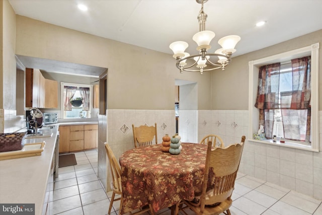 tiled dining space featuring a notable chandelier and sink