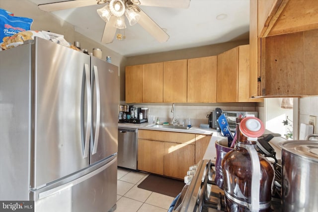 kitchen with ceiling fan, sink, stainless steel appliances, decorative backsplash, and light tile patterned floors