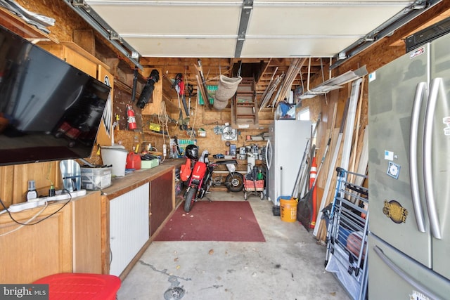 garage featuring a workshop area and stainless steel refrigerator