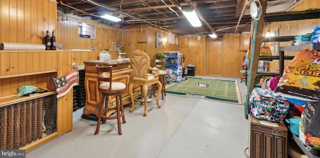 basement with bar and wooden walls