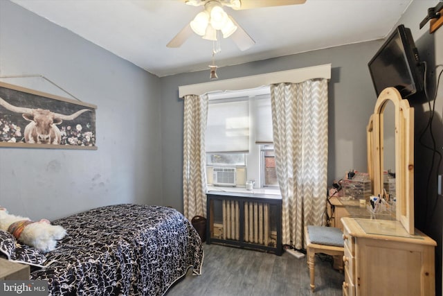 bedroom featuring hardwood / wood-style floors, radiator, cooling unit, and ceiling fan