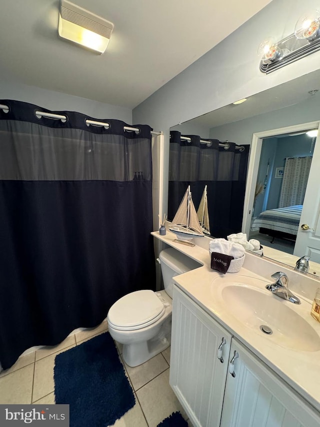 bathroom with toilet, vanity, and tile patterned floors