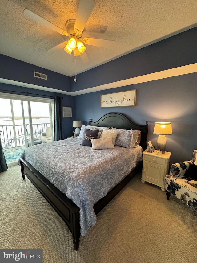 bedroom with access to exterior, a textured ceiling, carpet floors, and ceiling fan