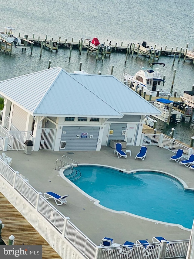 view of swimming pool with a patio area and a water view