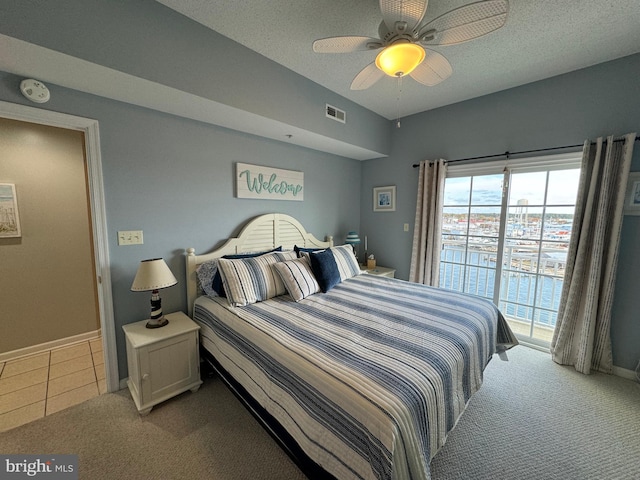 carpeted bedroom with a textured ceiling, access to outside, and ceiling fan