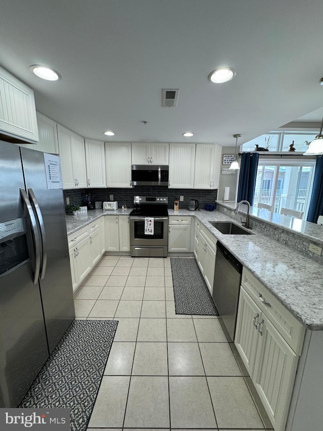 kitchen featuring white cabinets, hanging light fixtures, sink, and stainless steel appliances