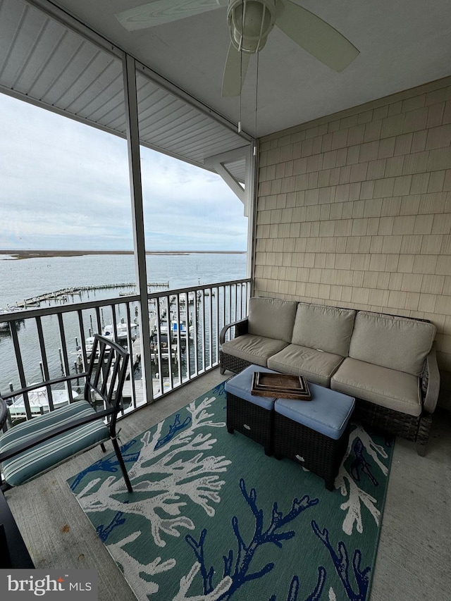 balcony featuring an outdoor living space, a water view, and ceiling fan