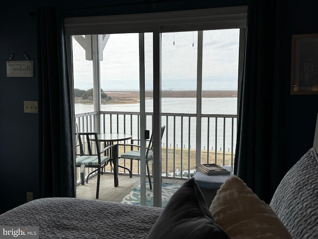 bedroom with wood-type flooring and a water view