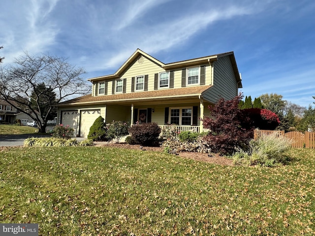 view of front of house featuring covered porch, a front yard, and a garage