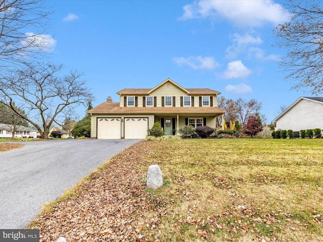 view of front property featuring a front lawn, covered porch, and a garage