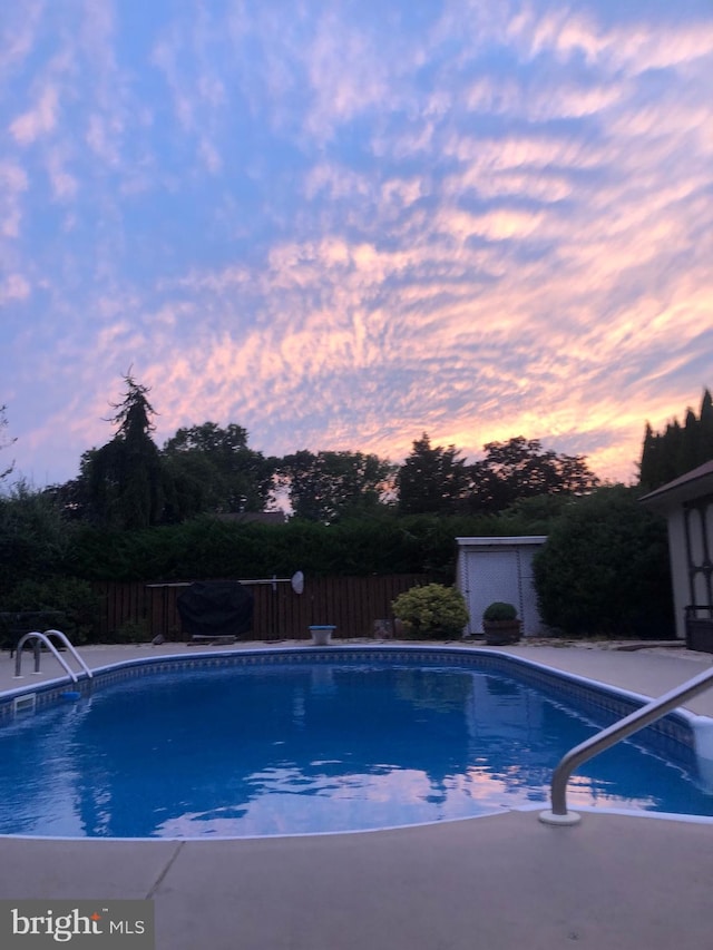 view of pool at dusk