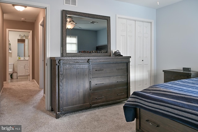 carpeted bedroom with ceiling fan and ensuite bath