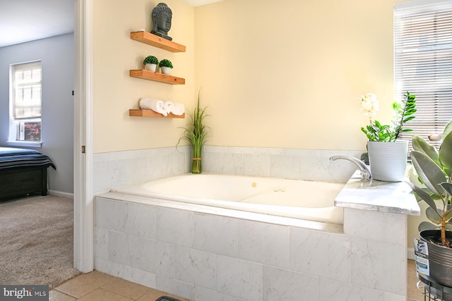 bathroom with tile patterned flooring and a relaxing tiled tub