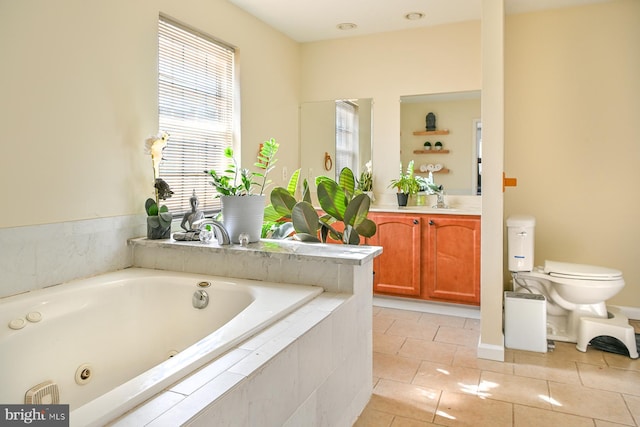 bathroom featuring toilet, vanity, tile patterned floors, and tiled tub