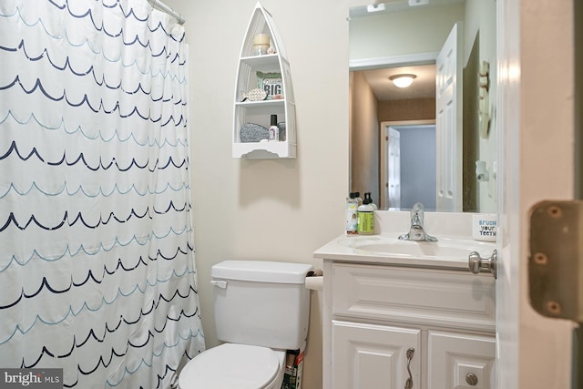 bathroom featuring toilet, vanity, and a shower with shower curtain