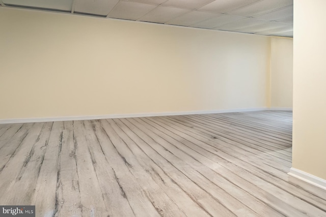 empty room with light wood-type flooring and a drop ceiling