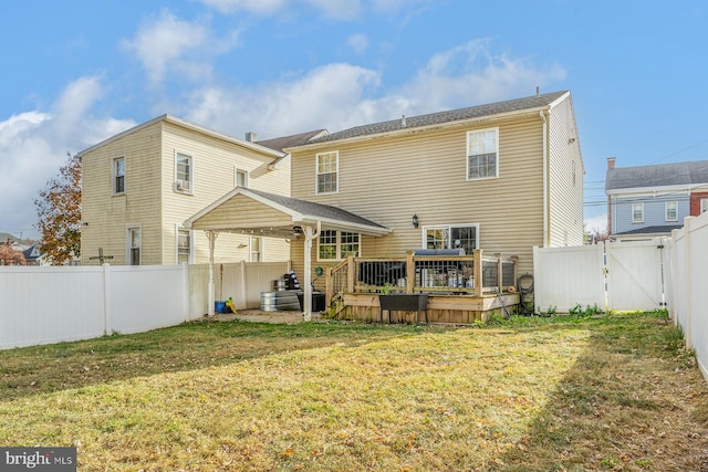 rear view of property featuring a lawn and a wooden deck