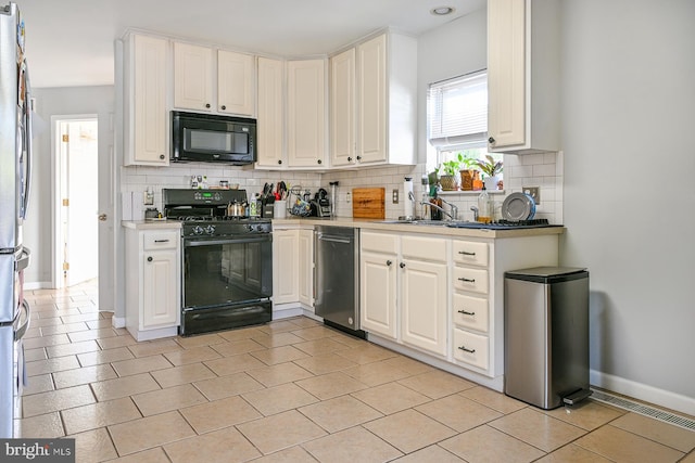 kitchen with white cabinets, black appliances, sink, and backsplash