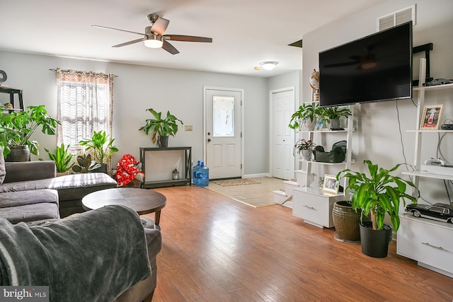 living room with wood-type flooring and ceiling fan