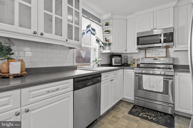 kitchen featuring tasteful backsplash, white cabinetry, appliances with stainless steel finishes, and sink