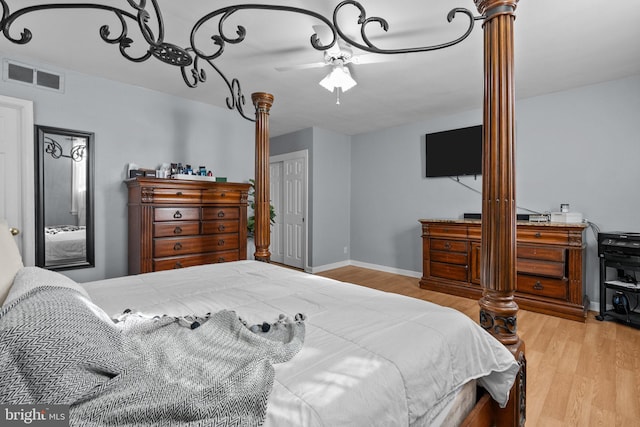 bedroom with ceiling fan, ornate columns, and light hardwood / wood-style flooring