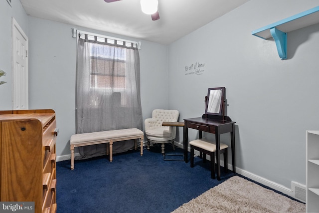 sitting room with dark colored carpet and ceiling fan