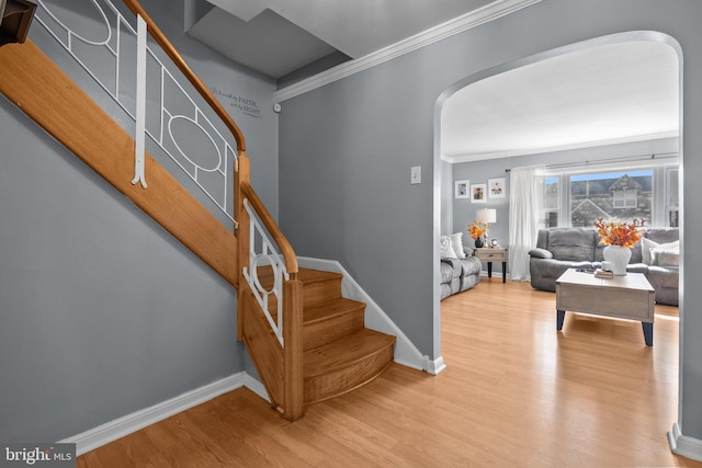 entryway with light hardwood / wood-style flooring and crown molding