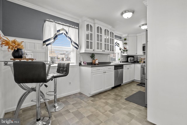 kitchen featuring white cabinetry, appliances with stainless steel finishes, sink, and backsplash