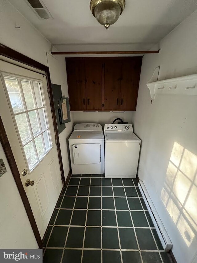 clothes washing area featuring cabinets, a baseboard heating unit, and independent washer and dryer