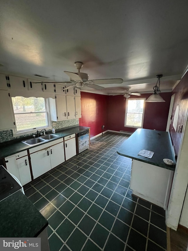 kitchen featuring a wealth of natural light, white cabinetry, sink, and tasteful backsplash