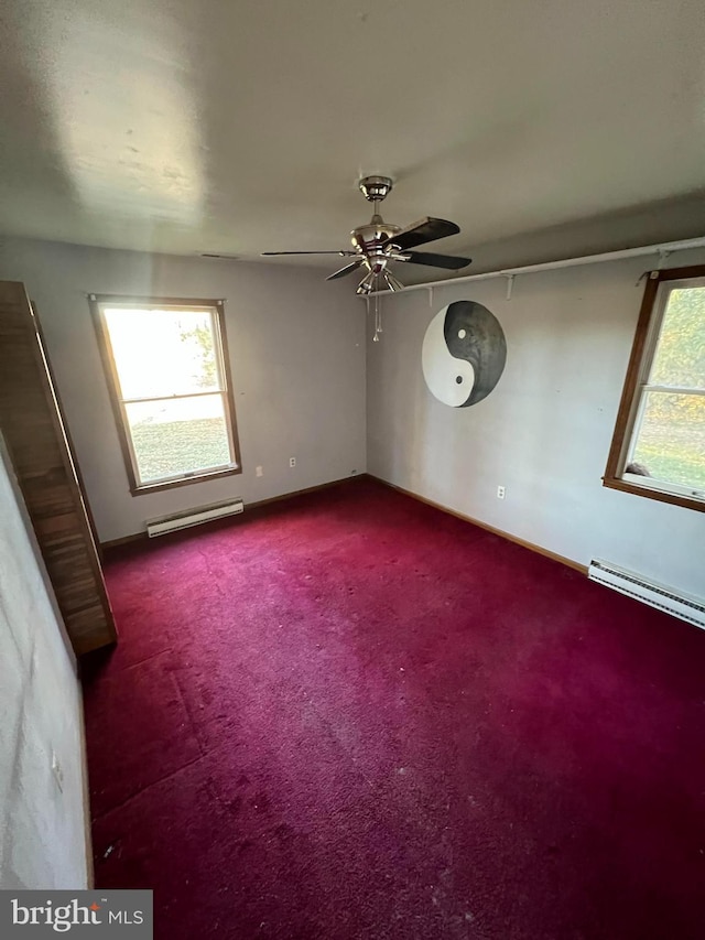 carpeted spare room with a baseboard radiator, a wealth of natural light, and ceiling fan