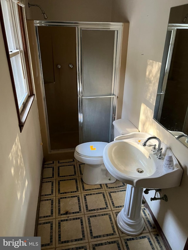 bathroom featuring tile patterned flooring, an enclosed shower, and toilet