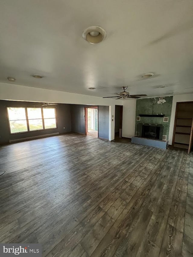 unfurnished living room featuring a fireplace, dark hardwood / wood-style floors, and ceiling fan