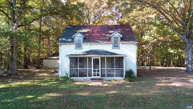 back of property featuring a lawn and a sunroom