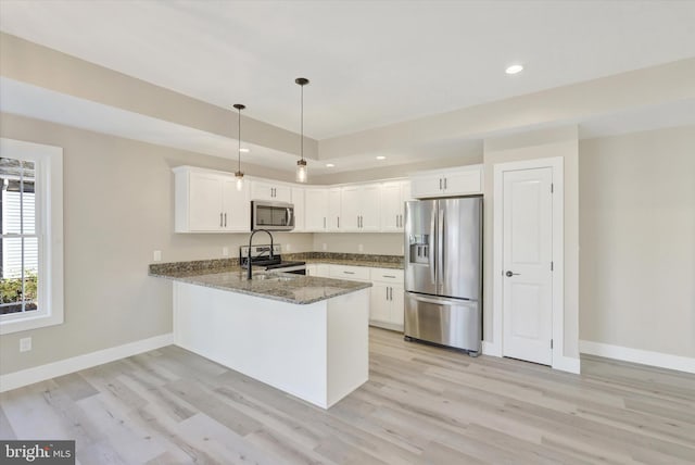 kitchen with kitchen peninsula, white cabinets, light hardwood / wood-style flooring, and appliances with stainless steel finishes