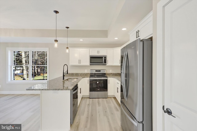 kitchen with stainless steel appliances, white cabinets, hanging light fixtures, sink, and stone counters