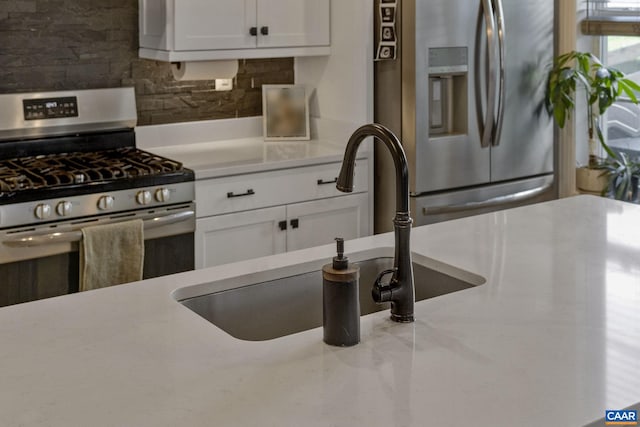 kitchen featuring white cabinetry, appliances with stainless steel finishes, sink, and backsplash