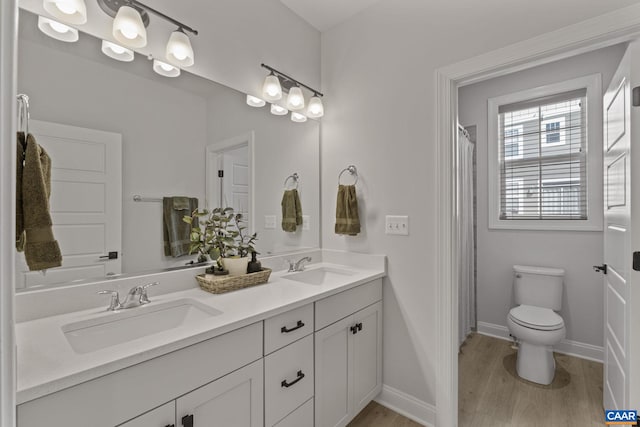 bathroom featuring wood-type flooring, toilet, and vanity