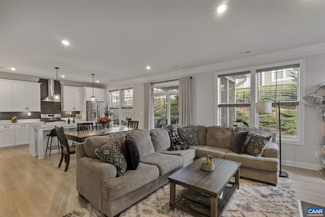 living room with ornamental molding and light hardwood / wood-style floors