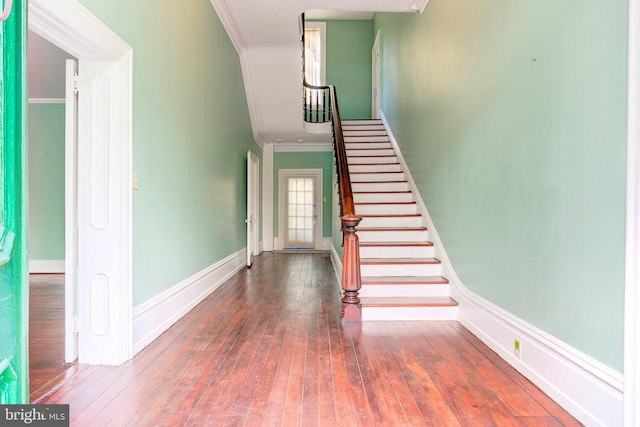 staircase featuring hardwood / wood-style flooring and ornamental molding