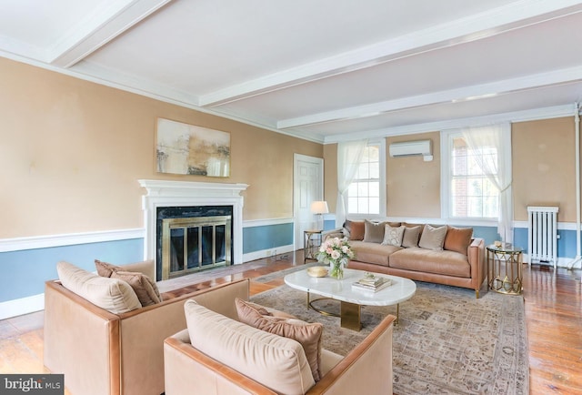 living room with a wall mounted air conditioner, beam ceiling, hardwood / wood-style flooring, a fireplace, and radiator heating unit