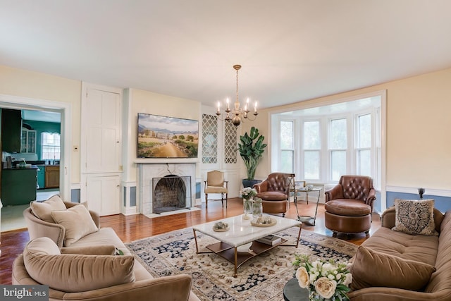 living room featuring a fireplace, hardwood / wood-style flooring, and a notable chandelier