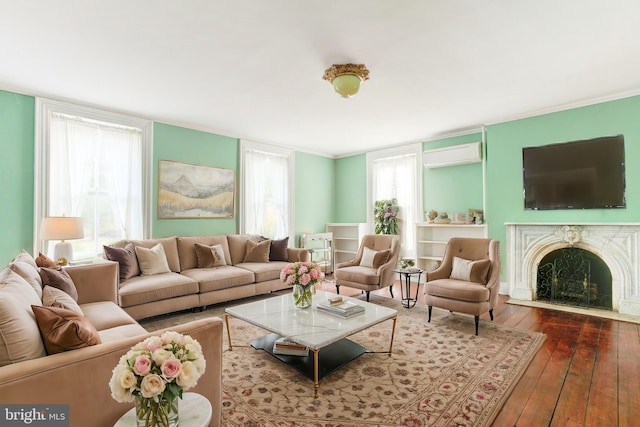 living room with a wall unit AC, a wealth of natural light, hardwood / wood-style floors, and ornamental molding