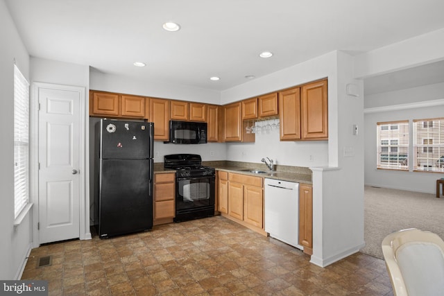 kitchen with black appliances, sink, and carpet