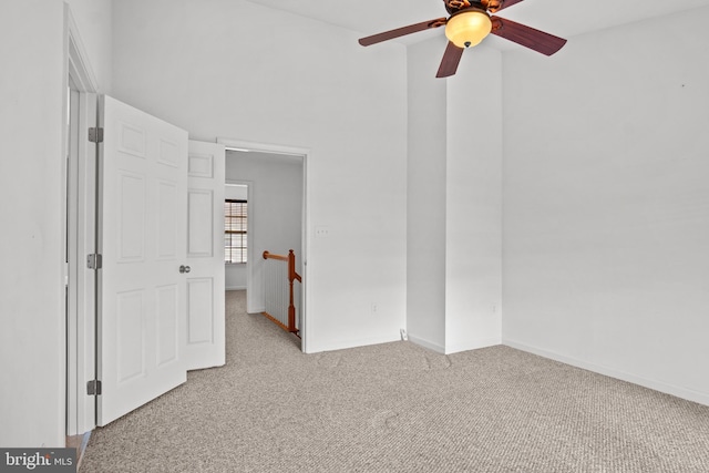 interior space with light carpet and ceiling fan