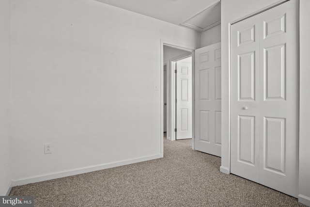 unfurnished bedroom with light carpet and a closet