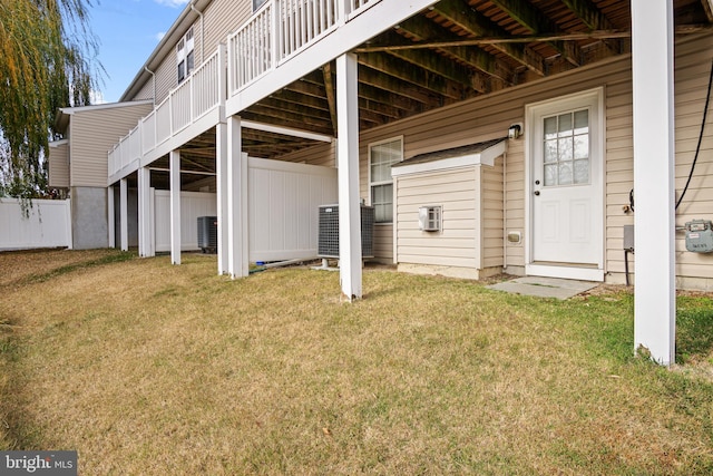 exterior space featuring a wooden deck, a yard, and cooling unit