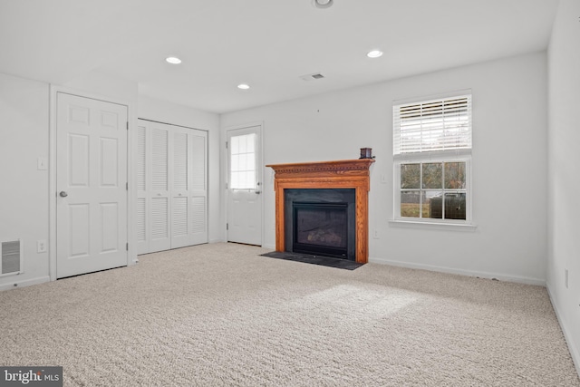 unfurnished living room with light carpet and plenty of natural light